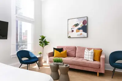 a living room with a pink couch and blue chairs at Bright 2BR Loft Sleeps 7 with Full Kitchen and Fast WiFi in San Diego