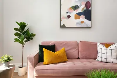 a pink couch with yellow pillows in a living room at Bright 2BR Loft Sleeps 7 with Full Kitchen and Fast WiFi in San Diego