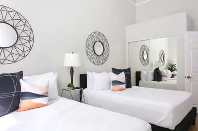 two white beds in a room with mirrors at Bright 2BR Loft Sleeps 7 with Full Kitchen and Fast WiFi in San Diego
