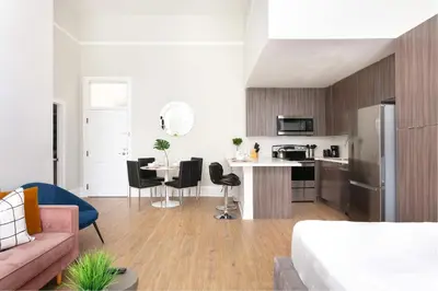 a living room and kitchen with a pink couch at Bright 2BR Loft Sleeps 7 with Full Kitchen and Fast WiFi in San Diego