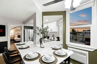 a kitchen and dining room with a white table and chairs at Updated Historic Suite with Queen Bed and Kitchen in San Diego