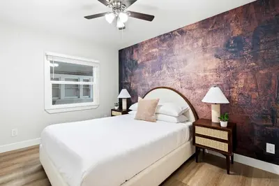 a bedroom with a large bed with a ceiling fan at Updated Historic Suite with Queen Bed and Kitchen in San Diego