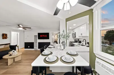 a kitchen and living room with a white table and chairs at Updated Historic Suite with Queen Bed and Kitchen in San Diego