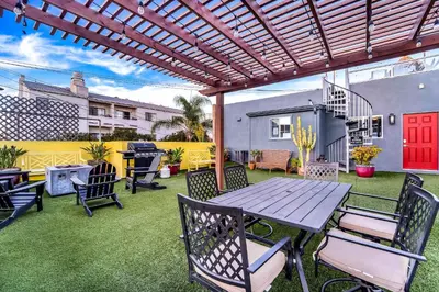 a patio with a wooden table and chairs and a grill at Historic Apartment with Roof Deck in the Heart of North Park in San Diego