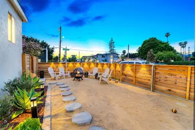 a patio with white chairs and a table and a fence at Spacious Group Getaway Games BBQ with Free Parking in San Diego