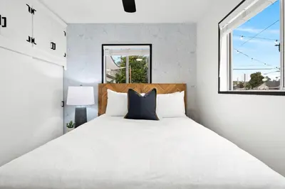 a bedroom with a large white bed with a window at Spacious Group Getaway Games BBQ with Free Parking in San Diego