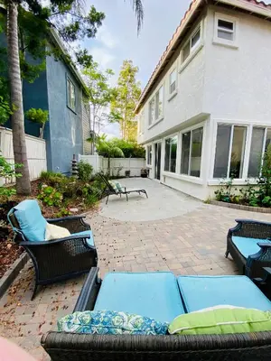 a patio with chairs and tables and a house at Serene Beach Retreat in Encinitas