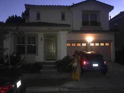 a woman standing in front of a house at night at Serene Beach Retreat in Encinitas
