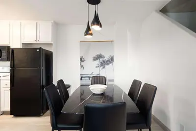 a dining room table with chairs and a black refrigerator at Walk to beach Great location Villa in San Diego