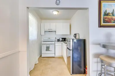 a kitchen with white cabinets and a refrigerator at 4 Mi to Shore Lake Elsinore Studio with Mtn Views in Lake Elsinore