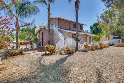 a pink house with palm trees in front of it at 4 Mi to Shore Lake Elsinore Studio with Mtn Views in Lake Elsinore