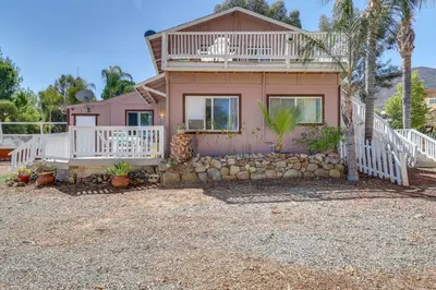 a pink house with a porch and a balcony at Lake Elsinore Apt 4 Mi to Water Pets Welcome! in Lake Elsinore