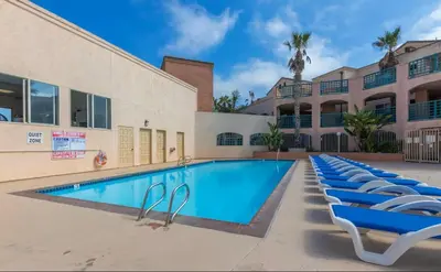 a swimming pool with lounge chairs in front of a building at Modern Coastal Escape Breathtaking Ocean in Imperial Beach