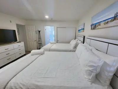 a large white bedroom with two beds and a television at Modern Coastal Escape Breathtaking Ocean in Imperial Beach