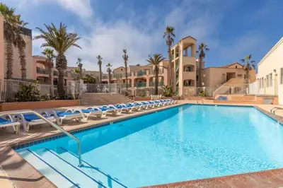 a large swimming pool with chairs and a building at Modern Coastal Escape Breathtaking Ocean in Imperial Beach