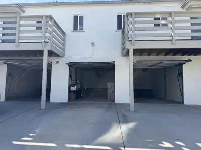 a white building with two garage doors and a ramp at Relaxing Retreat in North Park in San Diego