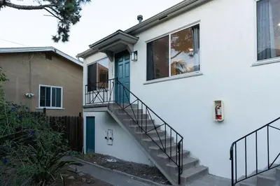 a white house with a staircase leading to a door at Relaxing Retreat in North Park in San Diego
