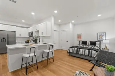 a kitchen and living room with a bed in the background at Spacious Modern Farmhouse Retreat with Two Kitchens and Pool - Ideal for Large Groups and Families in Poway