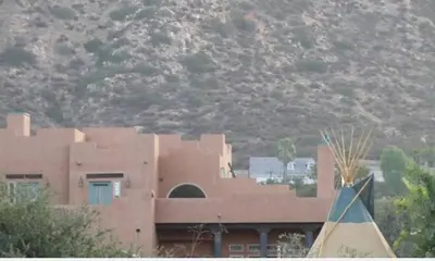 a large brown building with a mountain in the background at Mystic Canyon Inn Bed & Breakfast in El Cajon