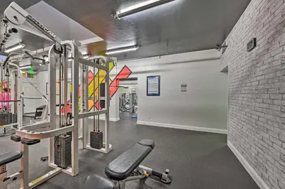 a gym with cardio equipment and a brick wall at Steps to Shore Condo with Resort Perks in Oceanside in Oceanside