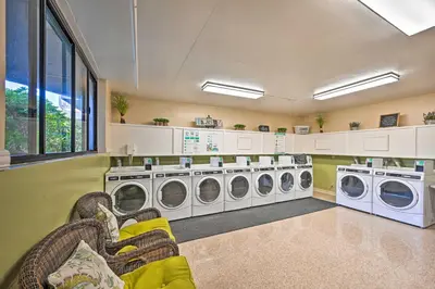 a laundry room with three washing machines and chairs at Steps to Shore Condo with Resort Perks in Oceanside in Oceanside