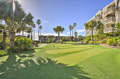 a golf course at a resort with palm trees at Steps to Shore Condo with Resort Perks in Oceanside in Oceanside
