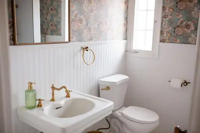 a bathroom with a sink and a toilet and a mirror at The Vintage La Mesa Tudor in La Mesa