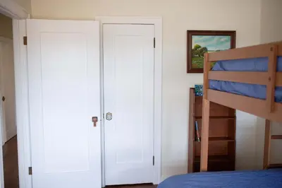 a bedroom with white doors and a bunk bed at The Vintage La Mesa Tudor in La Mesa