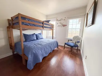 a bedroom with a bunk bed and a chair at The Vintage La Mesa Tudor in La Mesa