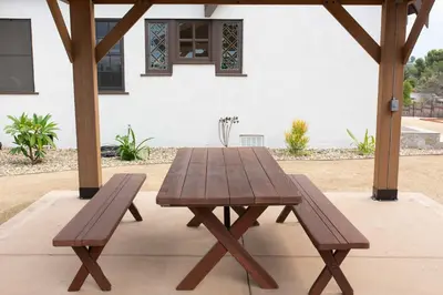 a wooden picnic table and two benches on a patio at The Vintage La Mesa Tudor in La Mesa
