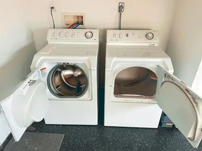 two washing machines with their doors open in a laundry room at Modern SD Oasis with Pool & HotTub in San Diego