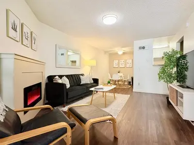 a living room with a couch and a fireplace at Prime Location and Stylish Apartment La Jolla UTC - Gym, Pool, Jacuzzi and Parking Access in San Diego