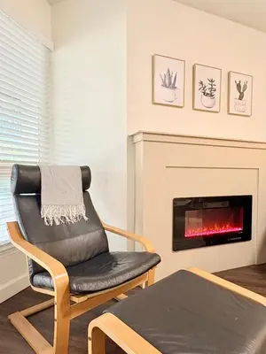 a living room with a chair and a fireplace at Prime Location and Stylish Apartment La Jolla UTC - Gym, Pool, Jacuzzi and Parking Access in San Diego
