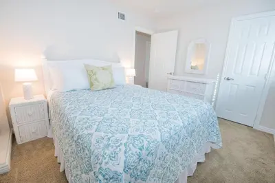 a bedroom with a bed with a blue and white bedspread at 7Br Retreat, Oceanview Balcony And Patio, Steps From Sand By Beachview Rentals in Newport Beach