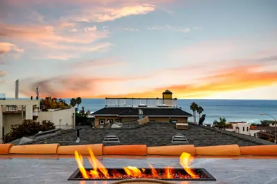 a fire pit in front of a building with the ocean at Oceanview Rooftop Escape Modern Spanish Decor in San Diego