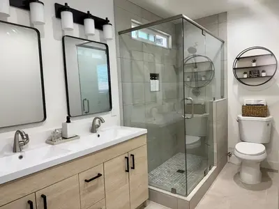 a bathroom with a glass shower and a toilet at Designer's Touch in San Diego