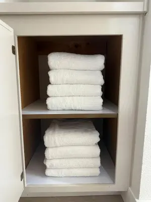 a stack of white towels in a cabinet at Designer's Touch in San Diego
