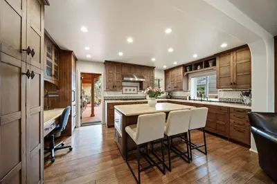 a kitchen with wooden cabinets and a table and chairs at Majestic Corner Coastal Haven in San Diego