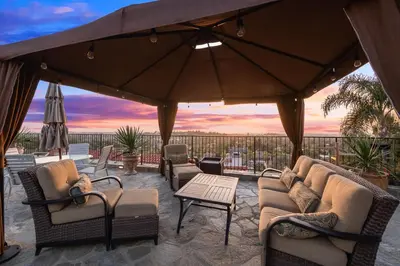 a patio with chairs and tables and an umbrella at North County Oasis in Vista