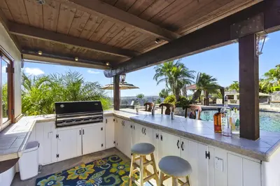 an outdoor kitchen with a view of the water at North County Oasis in Vista