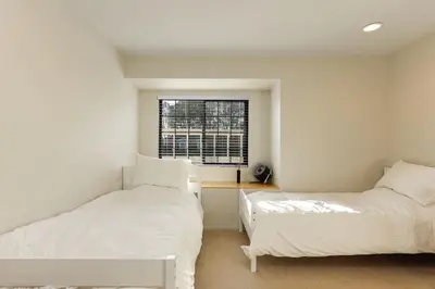 two beds in a white room with a window at Hilltop Escape in Carmel Valley in San Diego