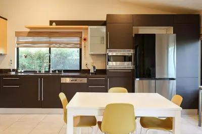 a kitchen with a white table and yellow chairs at Hilltop Escape in Carmel Valley in San Diego
