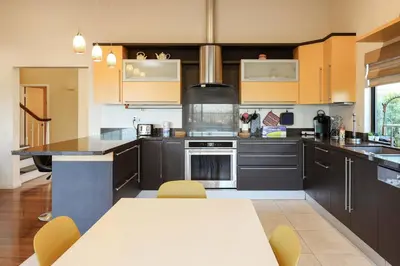a kitchen with brown cabinets and a white table in it at Hilltop Escape in Carmel Valley in San Diego