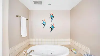 a bathroom with a bath tub and three birds on the wall at Beach - Walk - Village - Pool - Spa - Gym - Resort in Carlsbad