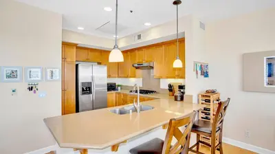 a kitchen with a counter top and a refrigerator at Beach - Walk - Village - Pool - Spa - Gym - Resort in Carlsbad