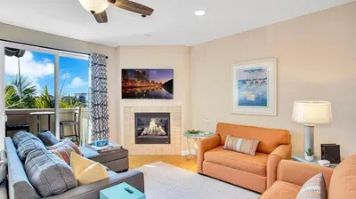 a living room with a couch and a fireplace at Beach - Walk - Village - Pool - Spa - Gym - Resort in Carlsbad