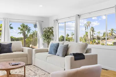 a living room with a couch and a large window at PB Ocean Views - Garage, Parking, King Bed in San Diego