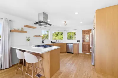 a kitchen with a white counter top and wooden cabinets at PB Ocean Views - Garage, Parking, King Bed in San Diego