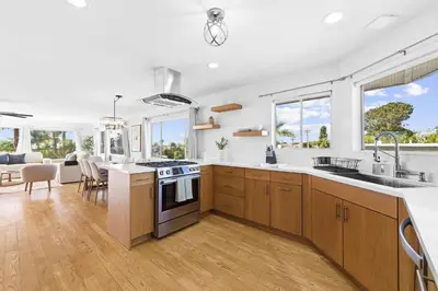 a kitchen with white walls and wooden cabinets at PB Ocean Views - Garage, Parking, King Bed in San Diego