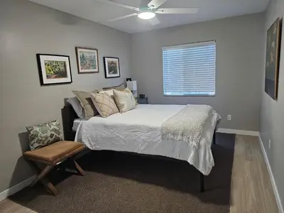 a bedroom with a bed and a chair and a window at Beautiful new construction 1br with full size appliances centrally located in La Mesa